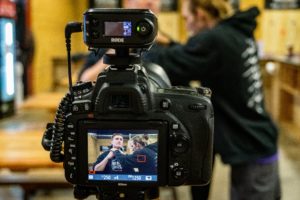 black DSLR camera being set up to film a person