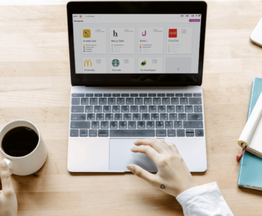an office desk with a laptop and stationery items