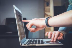 two people pointing at the laptop screen