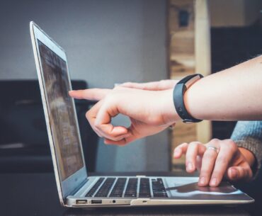 two people pointing at the laptop screen